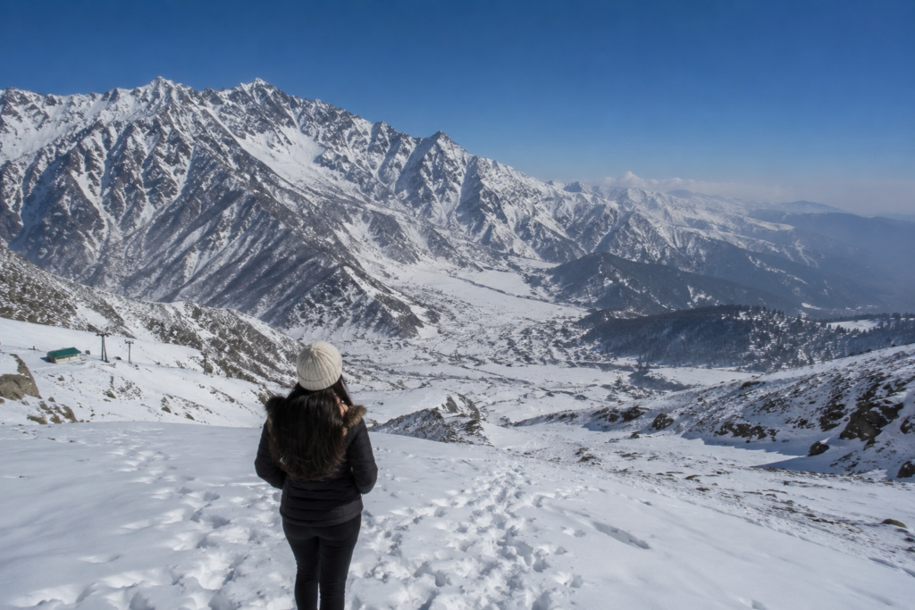Female traveller overlooking the snow-covered Apharwat Peak in Gulmarg, Kashmir