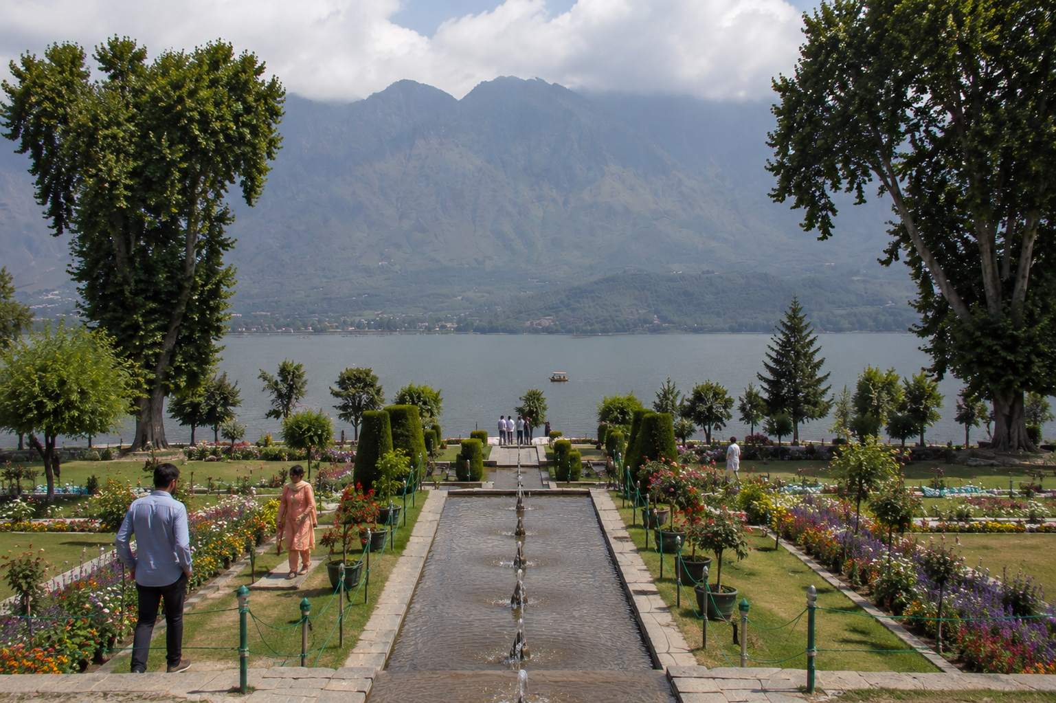 Visitors exploring Nishat Bagh Mughal Garden overlooking Dal Lake in Srinagar, Kashmir